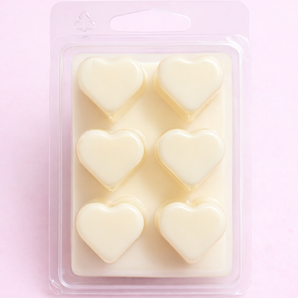 Heart-shaped wax melts in a clear plastic packaging on a pink background